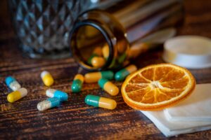 Difese immunitarie: quando ha senso integrarle davvero Close-up of vitamins, pills, and dried orange slice for cold relief.